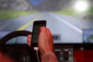 A driver holds a phone while one hand remains on the steering wheel. (Photo courtesy of United States Marine Corps)