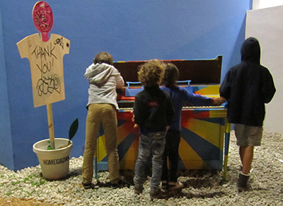 Kids play a piano during an art fair in Miami.