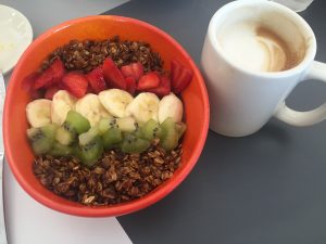 An açaí bowl topped with fruit and granola and a latte (Photo by Brittany Chandani)