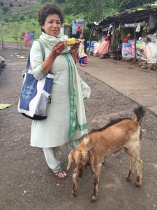 Aunt eating street food, being followed by goat (Photo by Brittany Chandani).