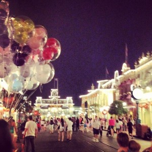 Main Street U.S.A. at night. The park's main street keeps itself alive with light shows and glowing balloons, while visitors explore the park's attractions and stores before closing time. Photo by: Donatella Vacca
